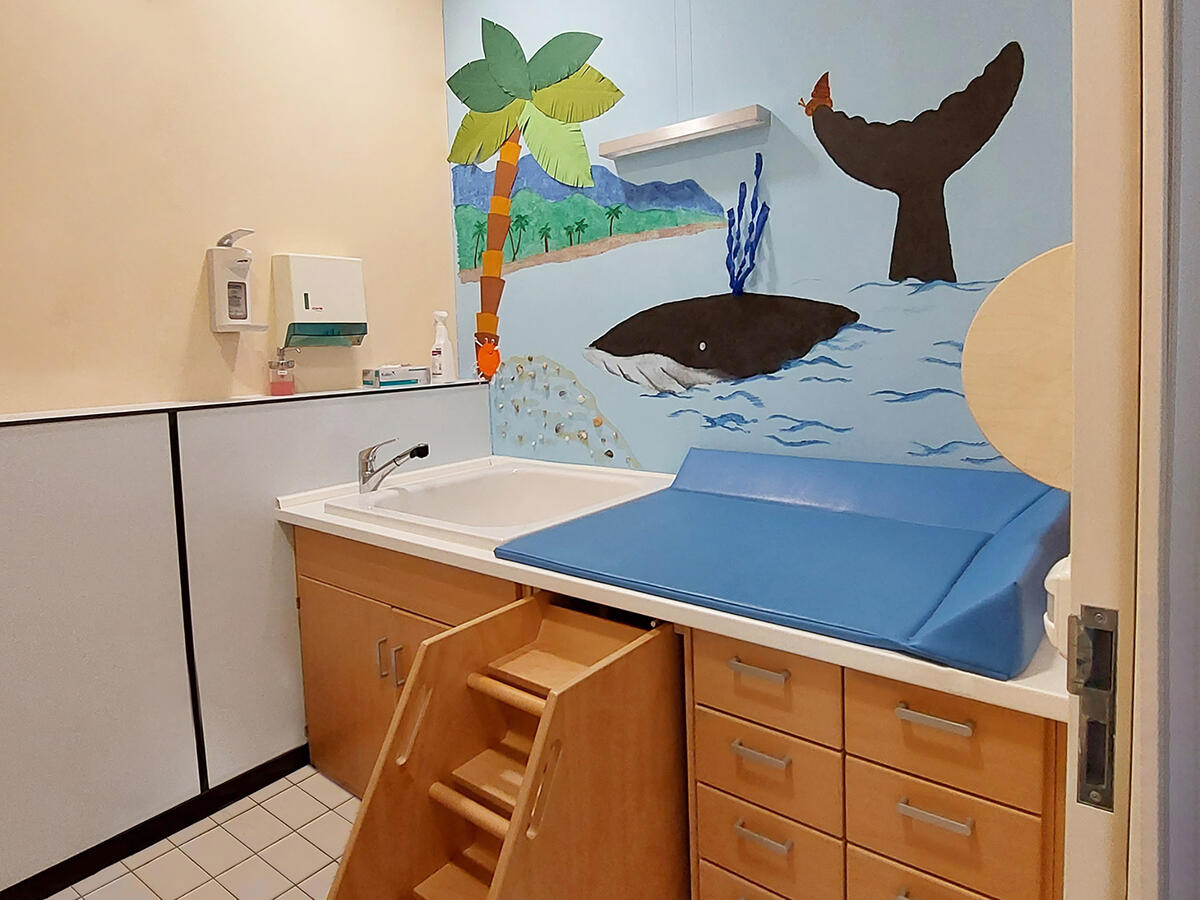 Nappy-changing room in the Löwenzahn daycare centre. A whale can be seen on the mural.