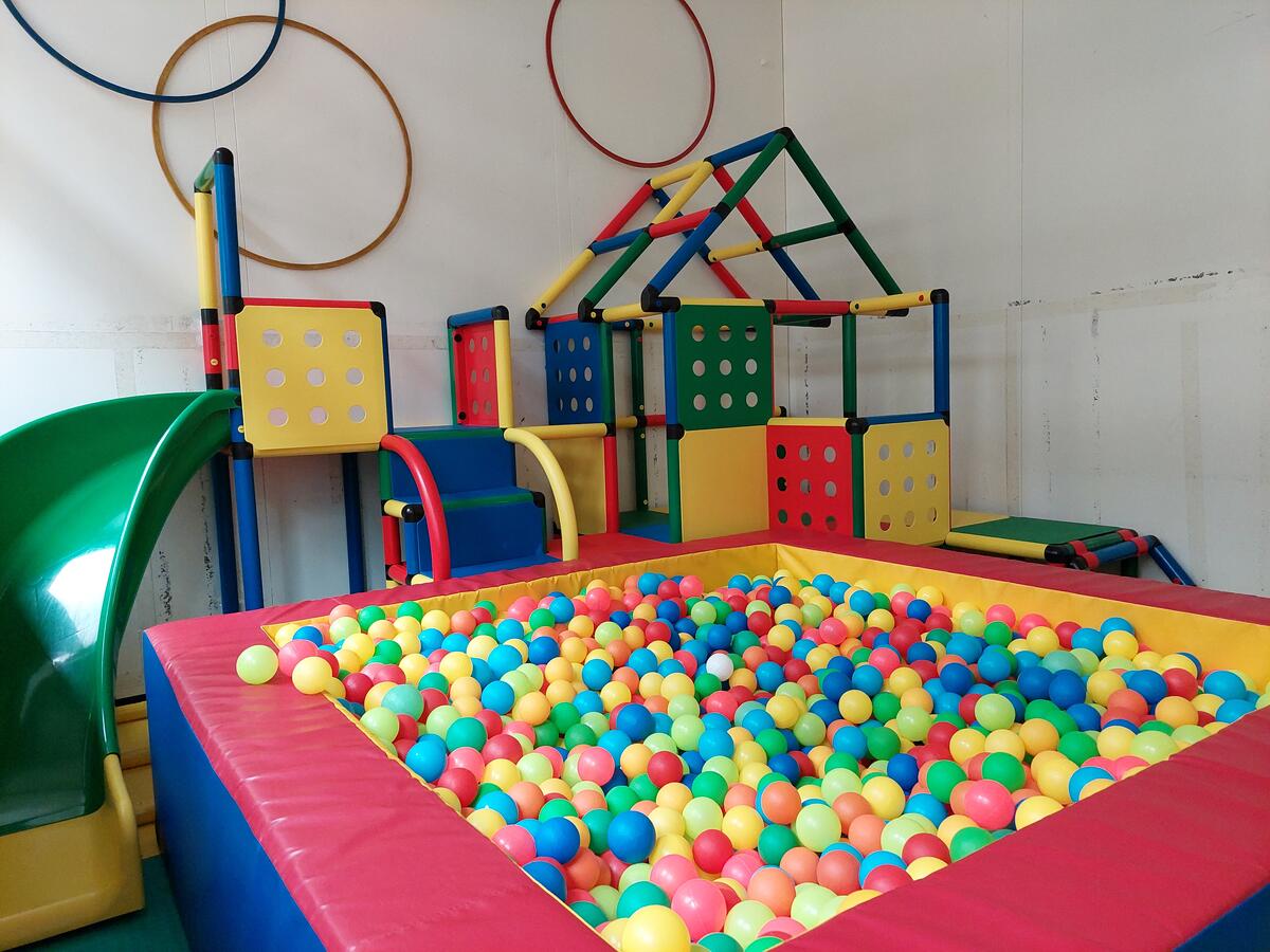 Gymnastics room in the Löwenzahn daycare centre with slide, climbing house and ball pool