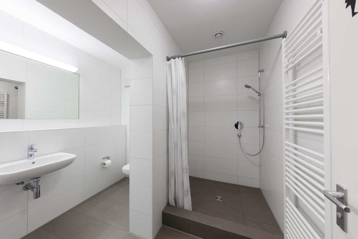 Badezimmer mit Dusche und Waschbecken im Anna Herrigel Wohnheim