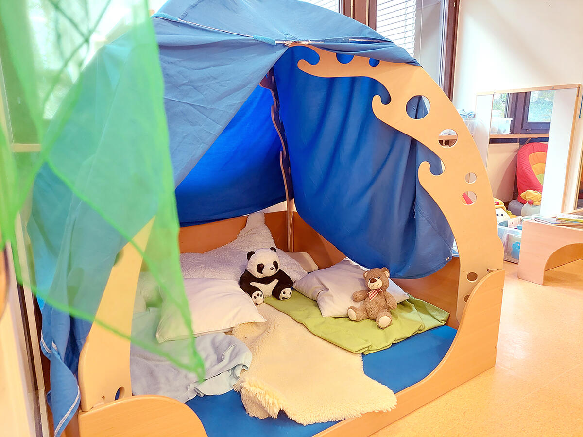 Tent in the group room of the Löwenzahn daycare centre with cushions, blankets and cuddly toys