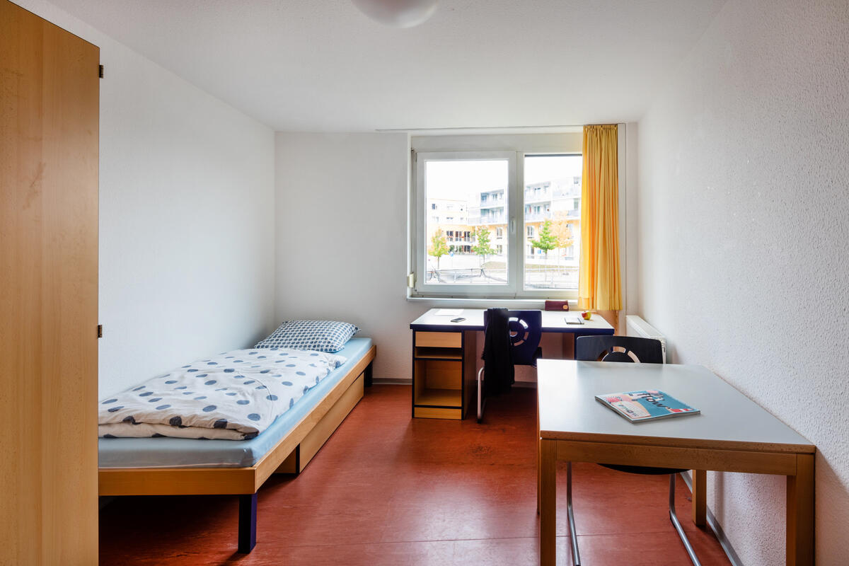 Zimmer mit Bett, Schreibtisch und Schrank in der Wohnanlage am Filderbahnplatz